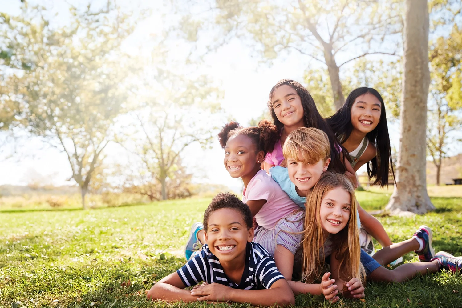 Kids dog piling in the park