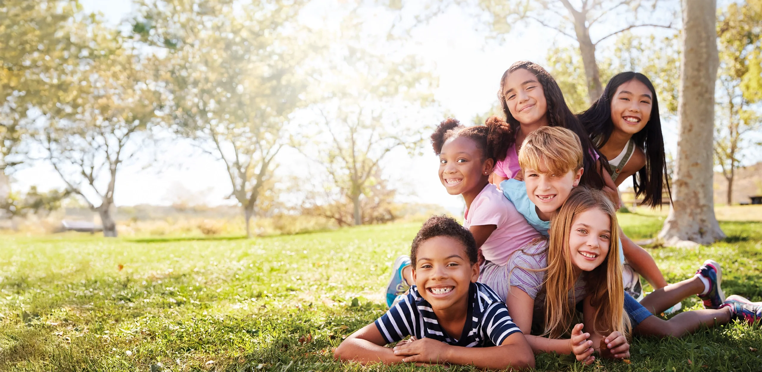 Kids dog piling in the park
