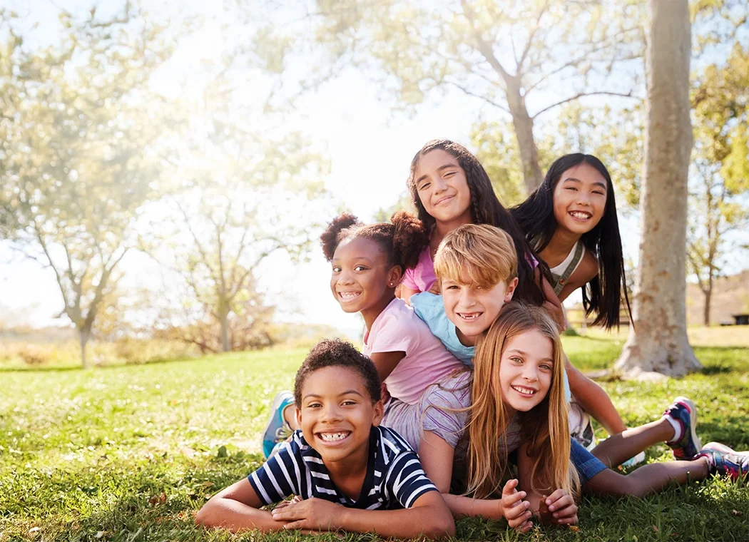 Kids dogpiling in a park