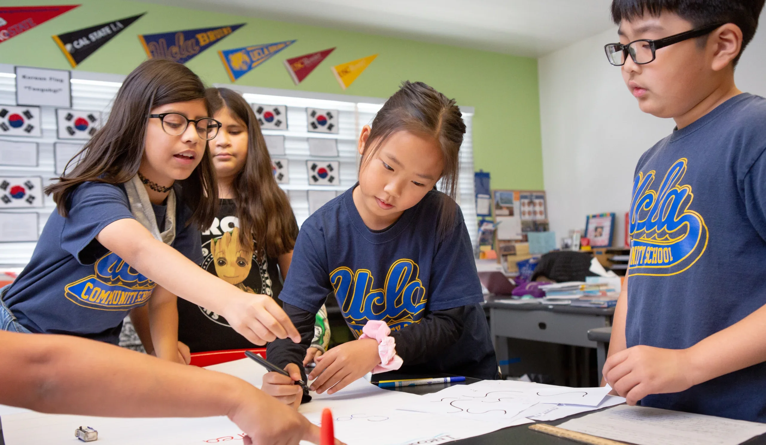 UCLA community school student working on project with classmates.