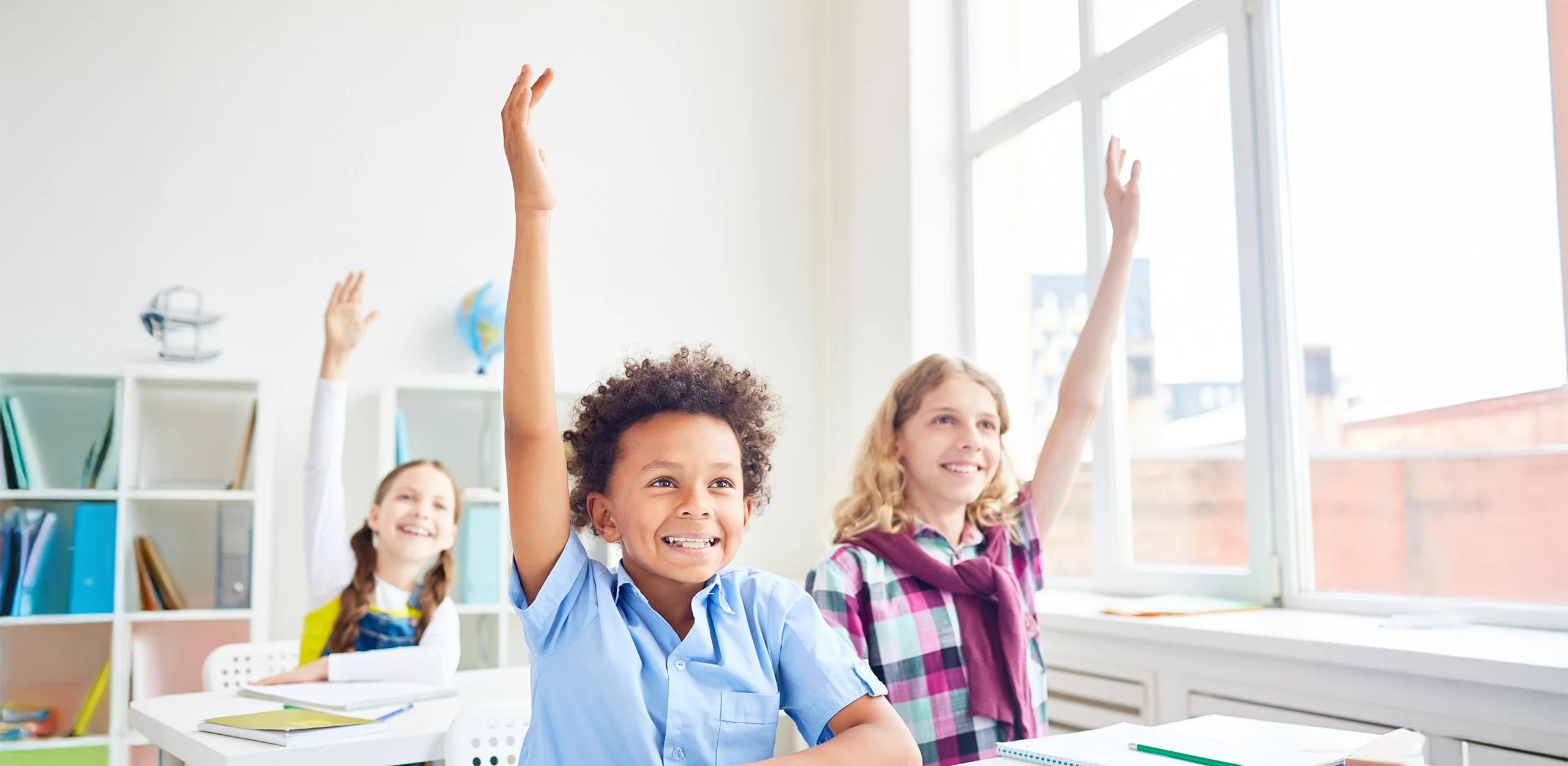 Student raising their hand in class.