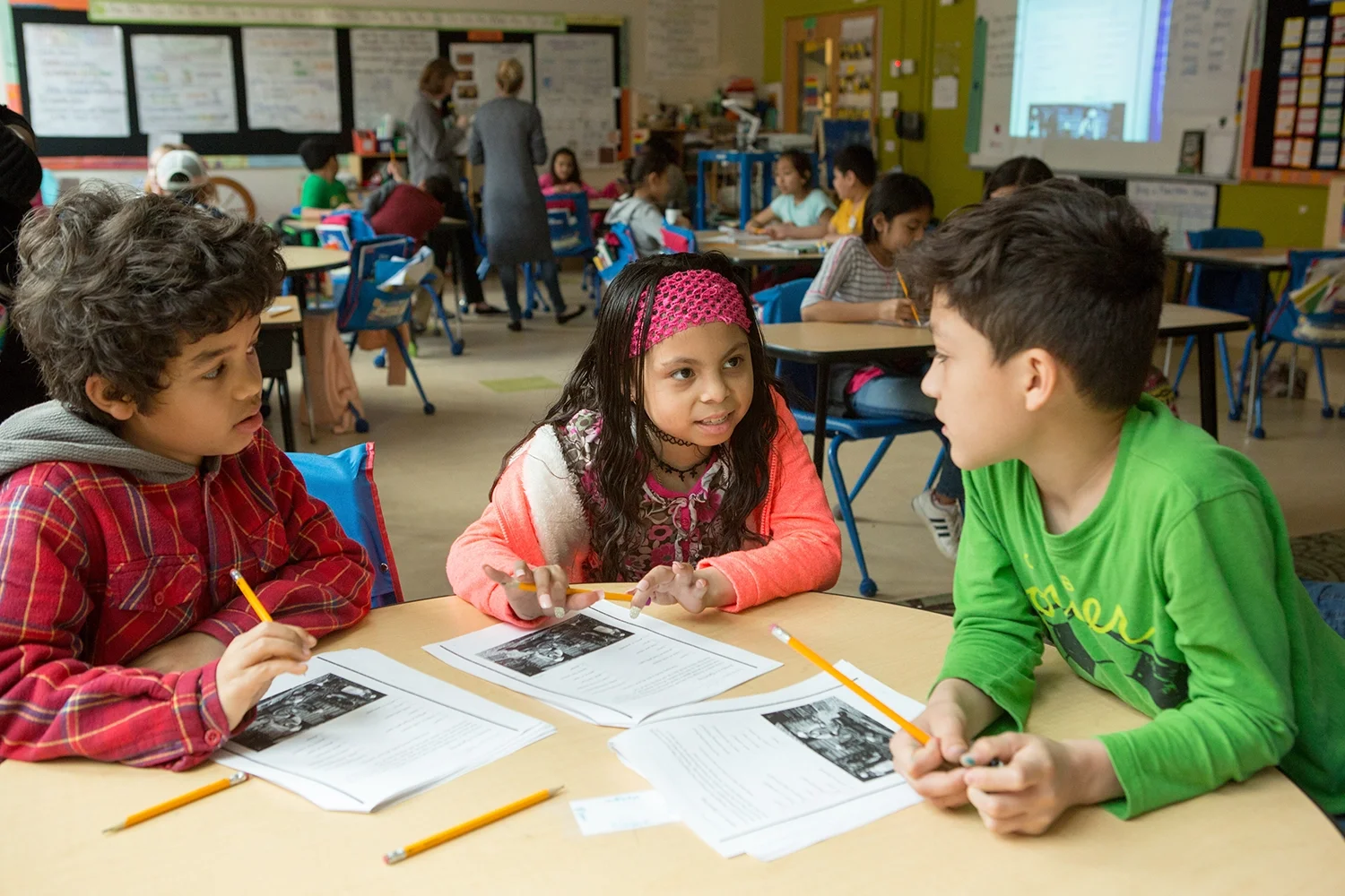 Three young students at a table working